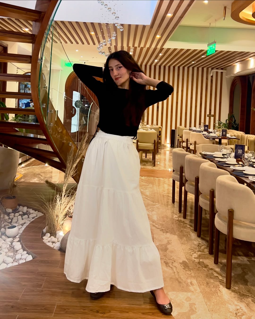 Chic black top complements flowing white skirt